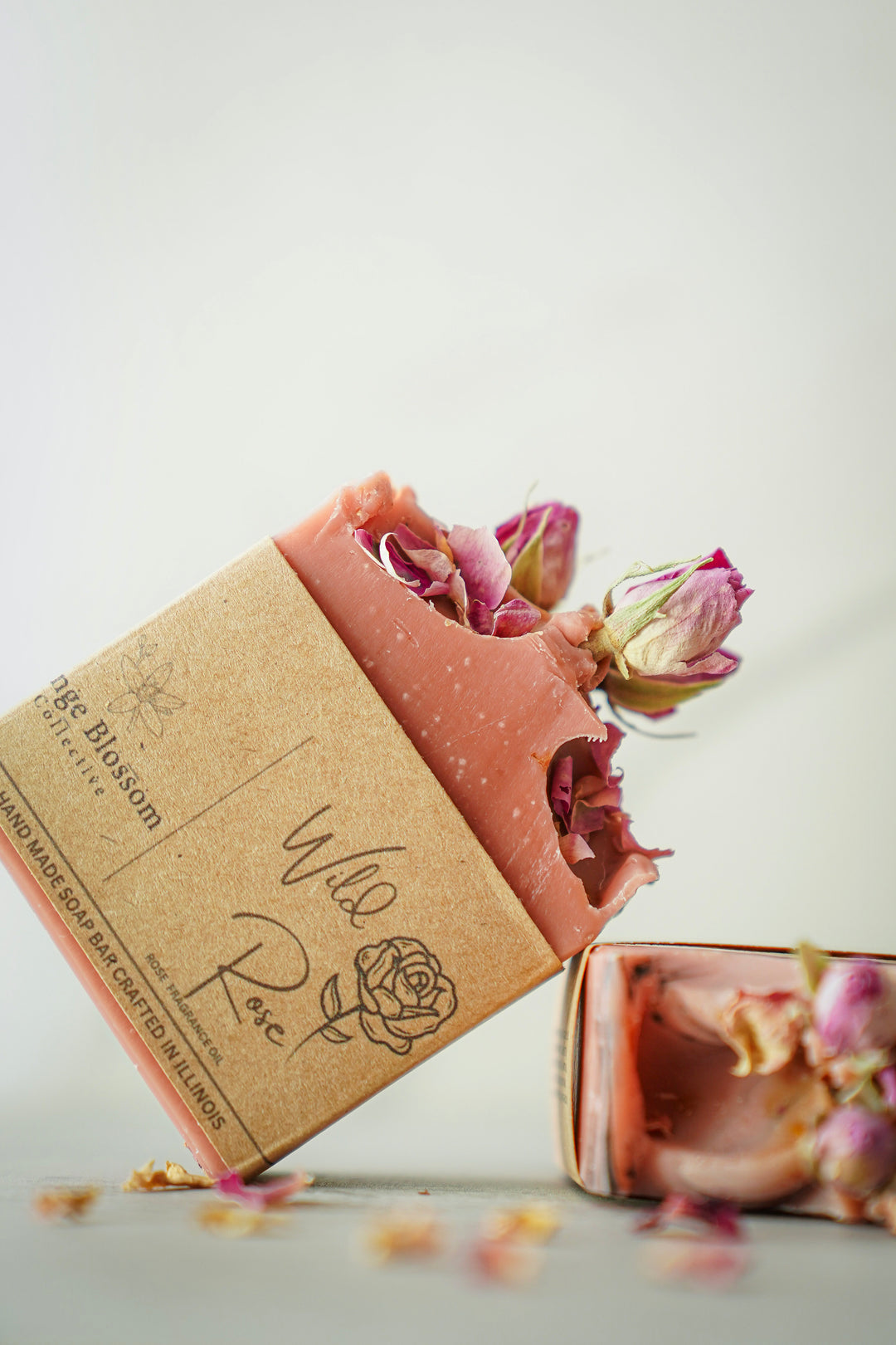 Orange Blossom Collective Wild Rose bar soap wrapped in kraft paper packaging with rose petal accents