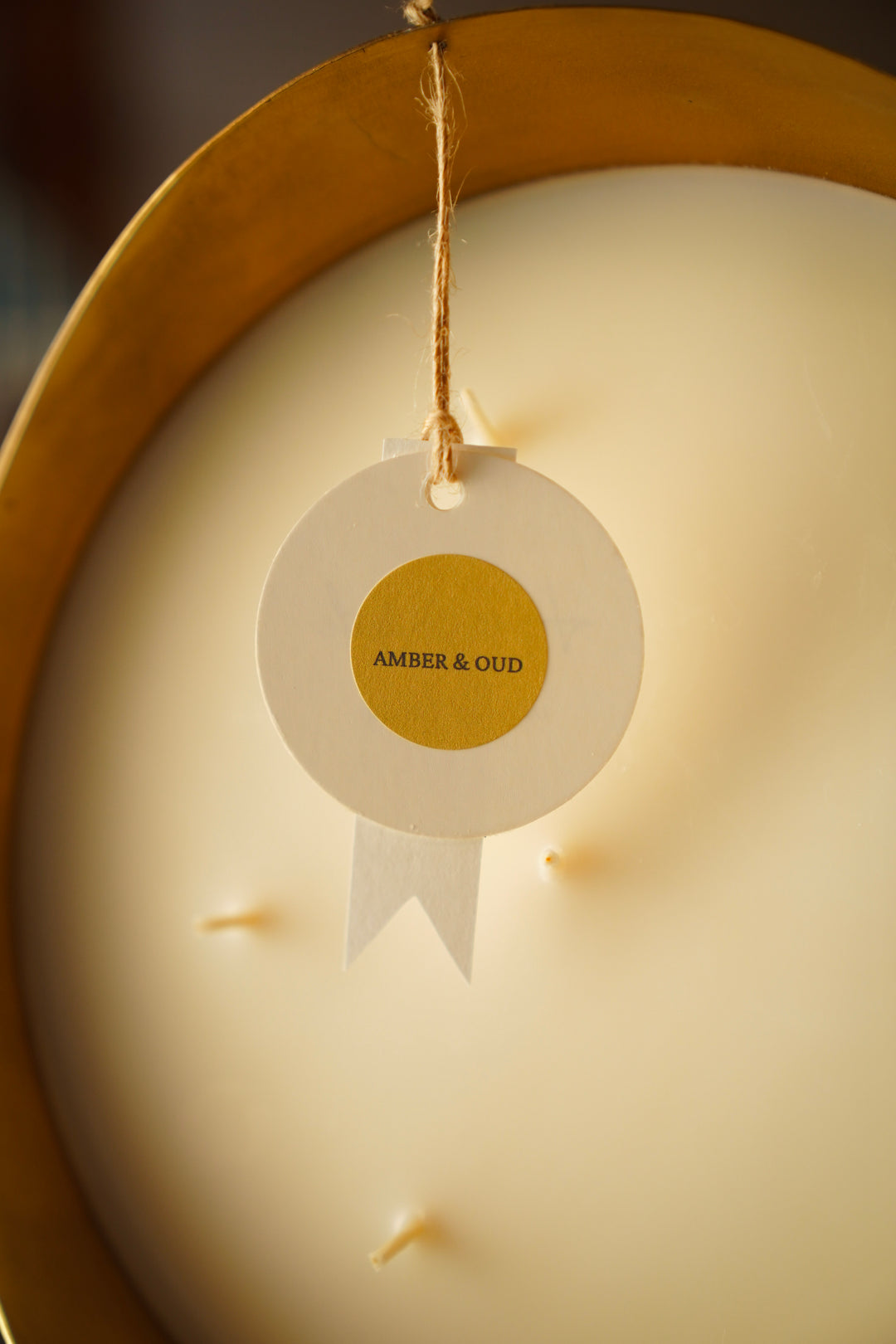 Amber & Oud scent label tag on candle wax, close-up