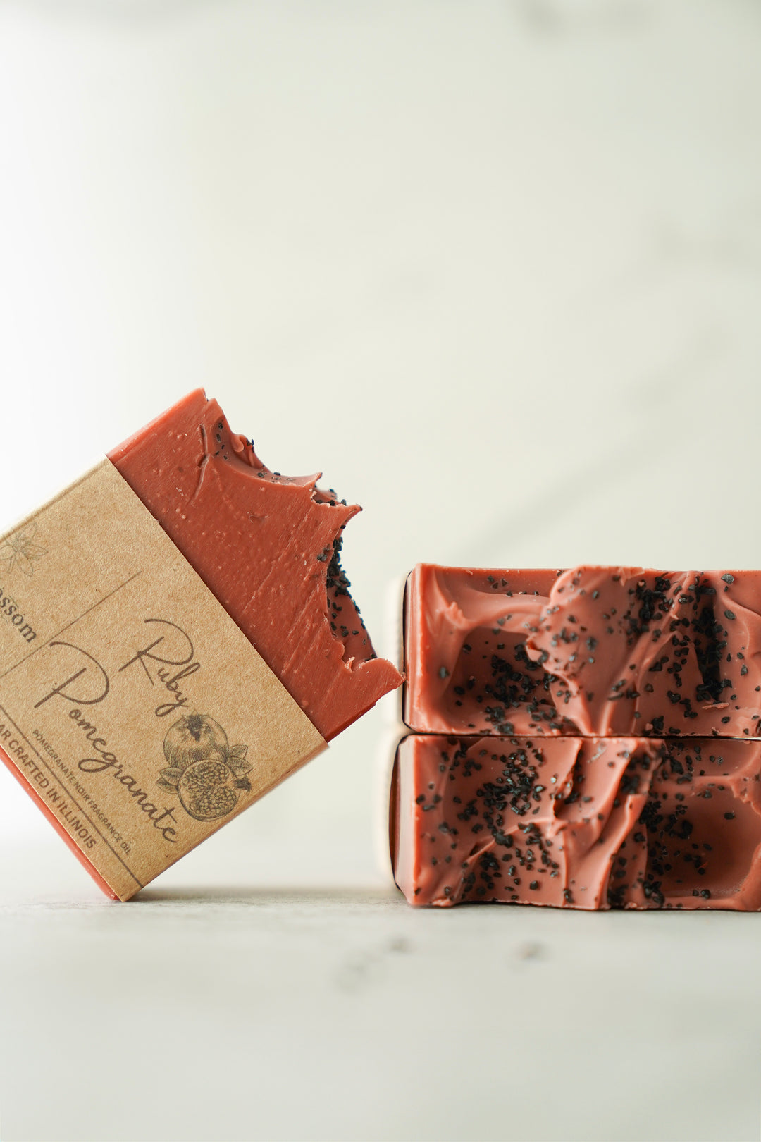 Orange Blossom Collective Fig & Pomegranate soap bar leaning upright showing kraft label packaging