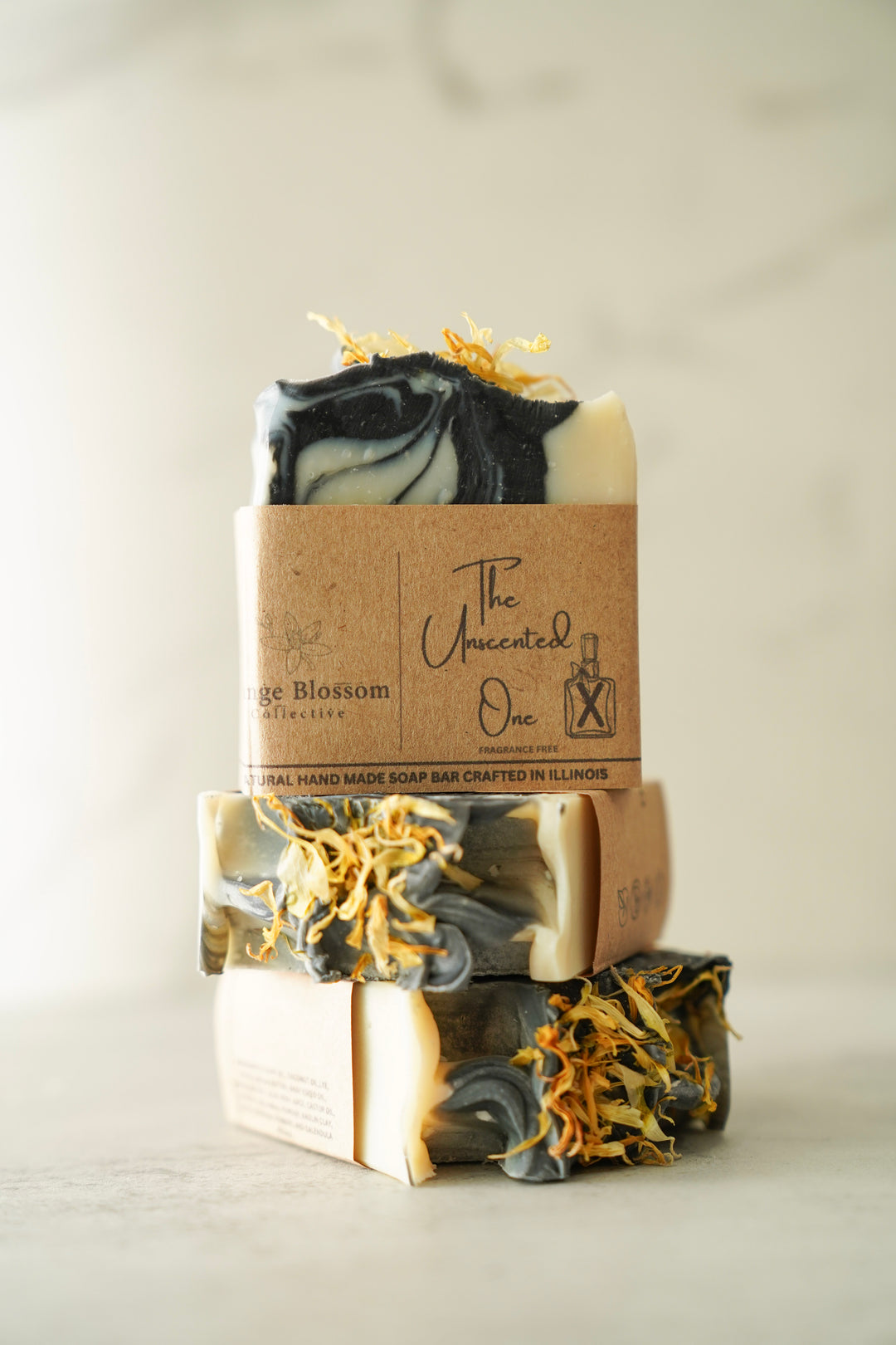 Stack of Orange Blossom Collective Unscented One soap bars in kraft wrap packaging