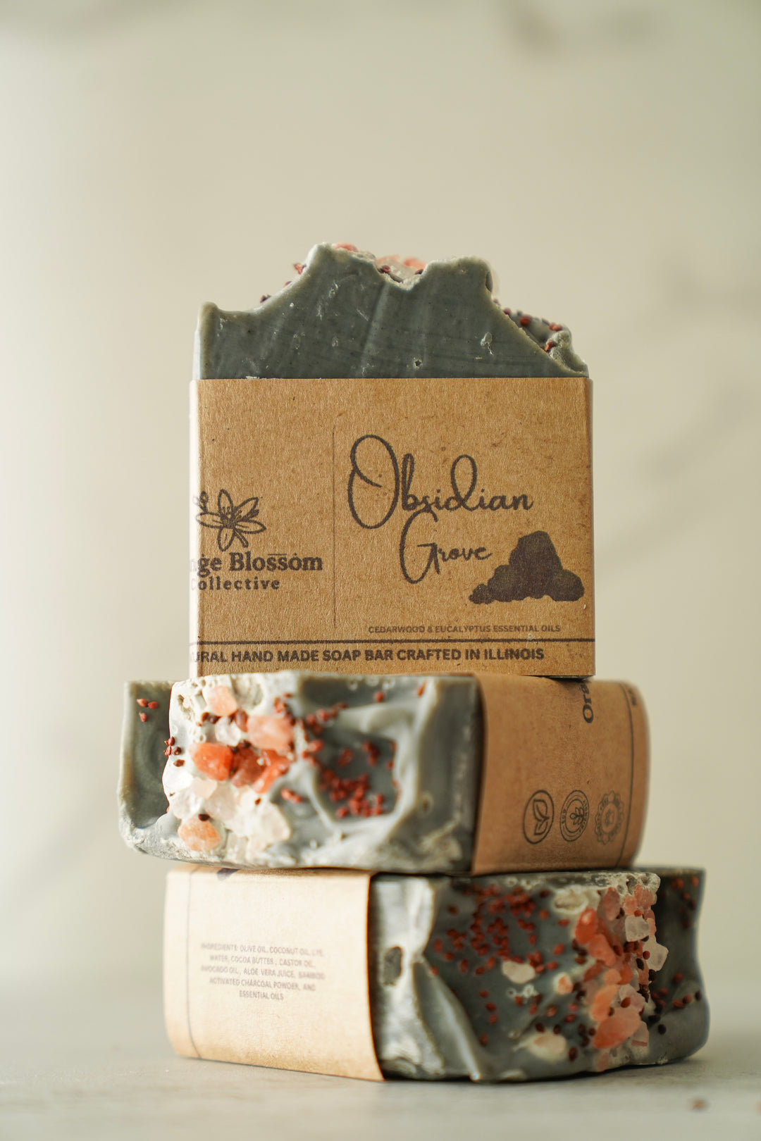 Obsidian Grove soap bar stacked with dark charcoal top exposed, kraft label visible
