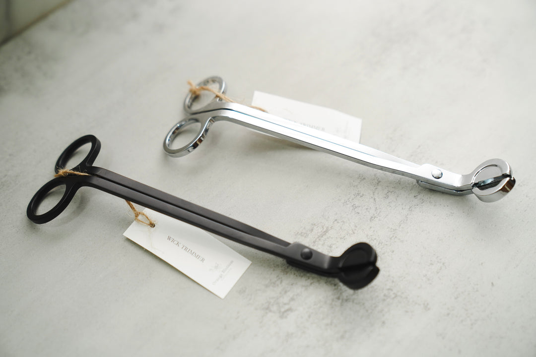 Two wick trimmers with brand tags side by side