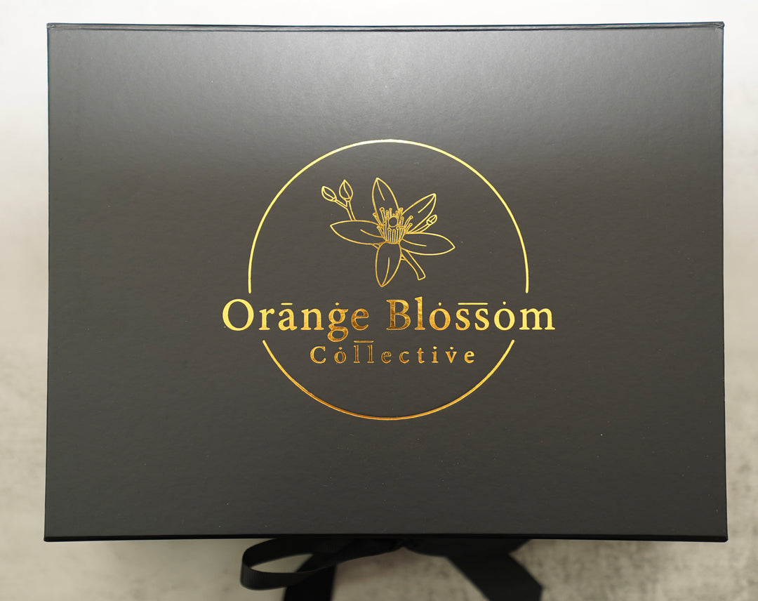 Black Orange Blossom Collective gift box with gold foil logo and ribbon